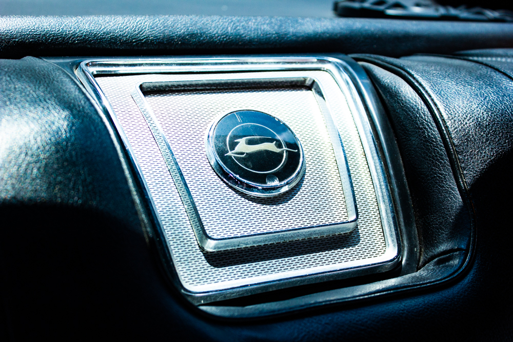 1967_Chevy_Impala_20220518 - (108) Example of Automotive Photography. Car Photography and Videography for Bring-a-Trailer, Auto Hunter, Barn Finder, Auto Trader, and any car and automobile sales sites. Car Photo is of a detail shot of the interior of the car, It has the Imapala emblem on the dashboard. The dashboard is black and the emblem is silver or chrome.
