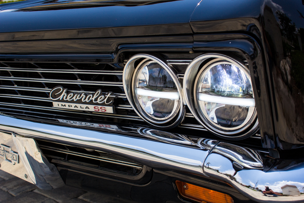 1967_Chevy_Impala_20220518 - (89) Example of Automotive Photography. Car Photography and Videography for Bring-a-Trailer, Auto Hunter, Barn Finder, Auto Trader, and any car and automobile sales sites. Car Photo is of an exterior picture the front headlight with some of the chrome grill and the Impala emblem.