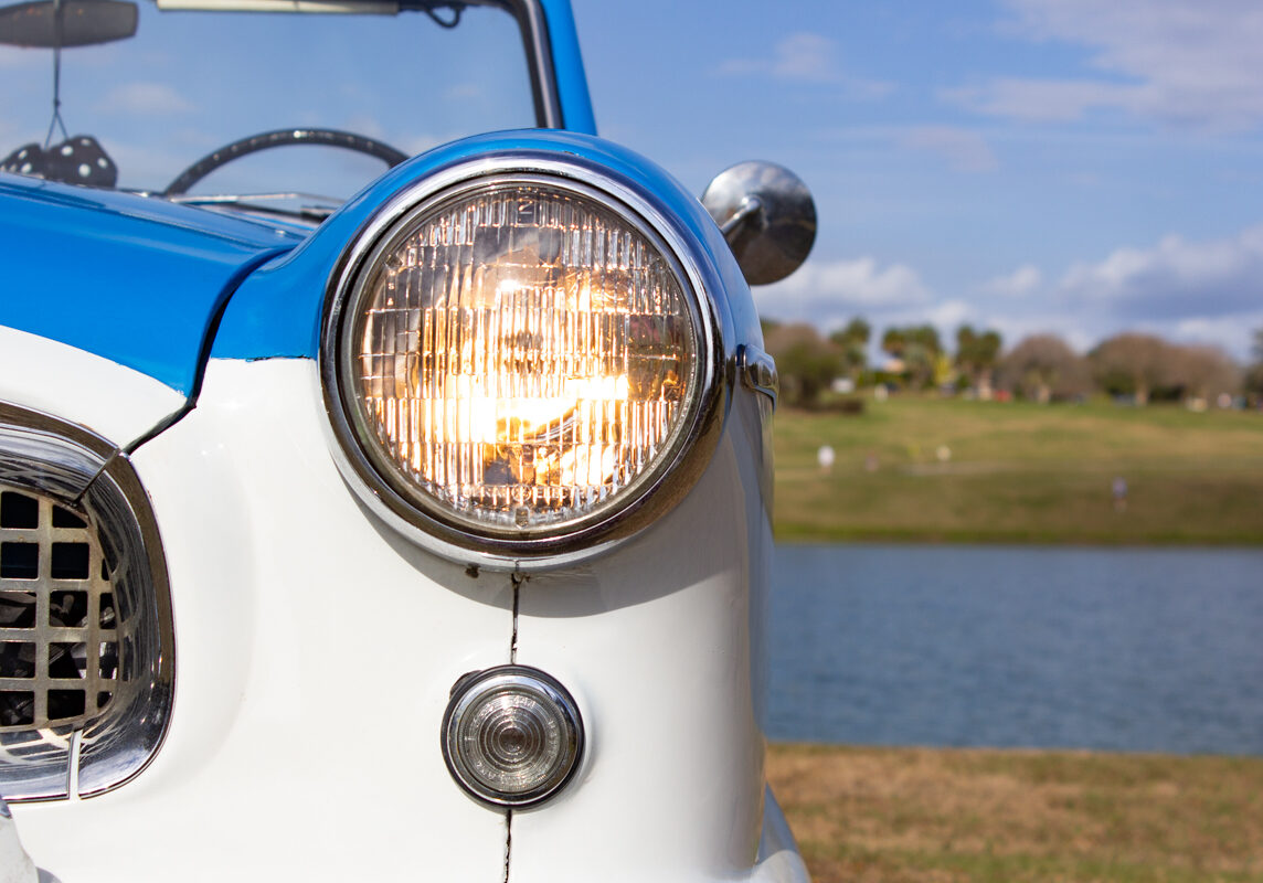 1956_Nash_Metropolitan_20230210 (90)comp Example of Automotive Photography. Car Photography and Videography for Bring-a-Trailer, Auto Hunter, Barn Finder, Auto Trader, and any car and automobile sales sites. Car Photo is of the driver's side headlamp/light of a blue and white 1956 Nash Metropolitan