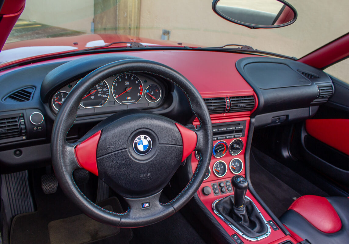 2000_BMW_M_Roadster_20230617 - (62)comp Example of Automotive Photography. Car Photography and Videography for Bring-a-Trailer, Auto Hunter, Barn Finder, Auto Trader, and any car and automobile sales sites. Car Photo is of the dashboard of a fire engine red 2000 BMW Roadster fromthe point of view of the driver.