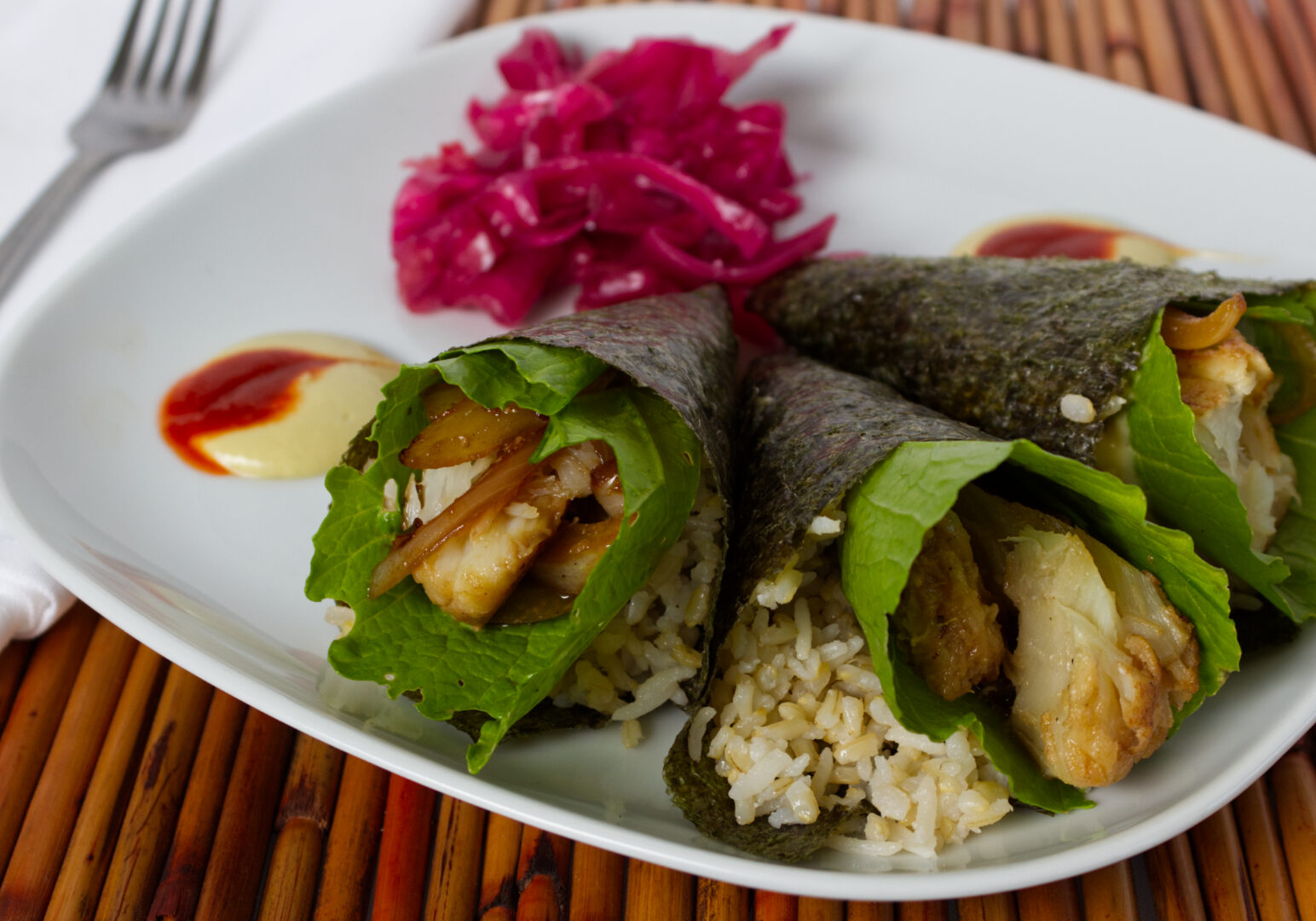 Image_04 Example of Food Photography for DoorDash, Uber Eats, Grub Hub, and any food delivery service app. Food Photo is of three seaweed wrapped fish wraps on a square plate with decorative garnishes on the plate with the food. The plate is positioned on a bamboo placemat for asthetic purposes.