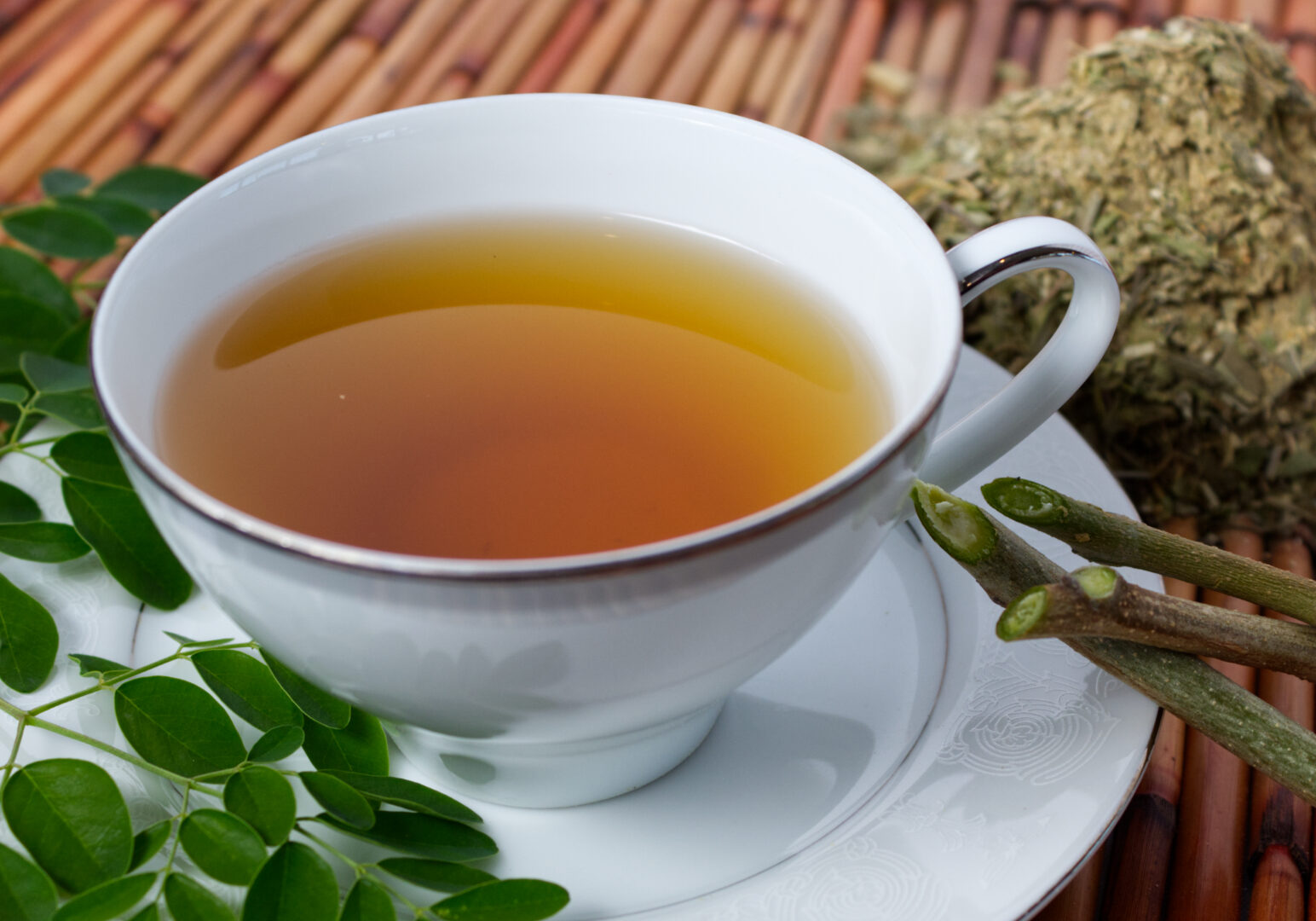 Image_10 Example of Food Photography for DoorDash, Uber Eats, Grub Hub, and any food delivery service app. Food Photo is of a tea cup with tea in it. The tea cup is sitting on a bamboo placemat and is surrounded by ingredients that makes up the tea for artistic asthetics.