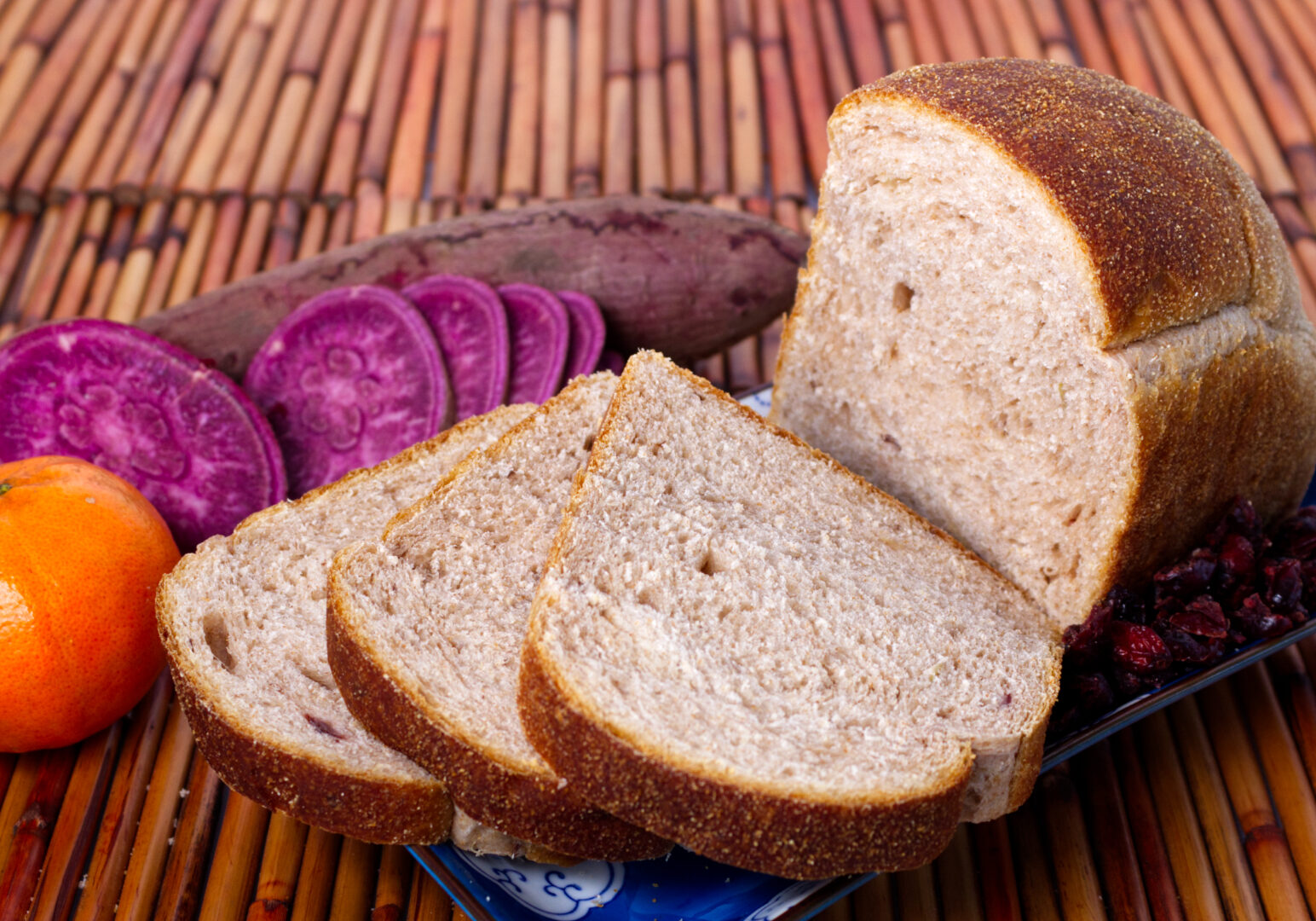 Image_09 Example of Food Photography for DoorDash, Uber Eats, Grub Hub, and any food delivery service app. Food Photo is of a loaf of bread. Bread in photo is surrounded by ingredients used in the bread. All this is positioned on a bamboo palce matt.